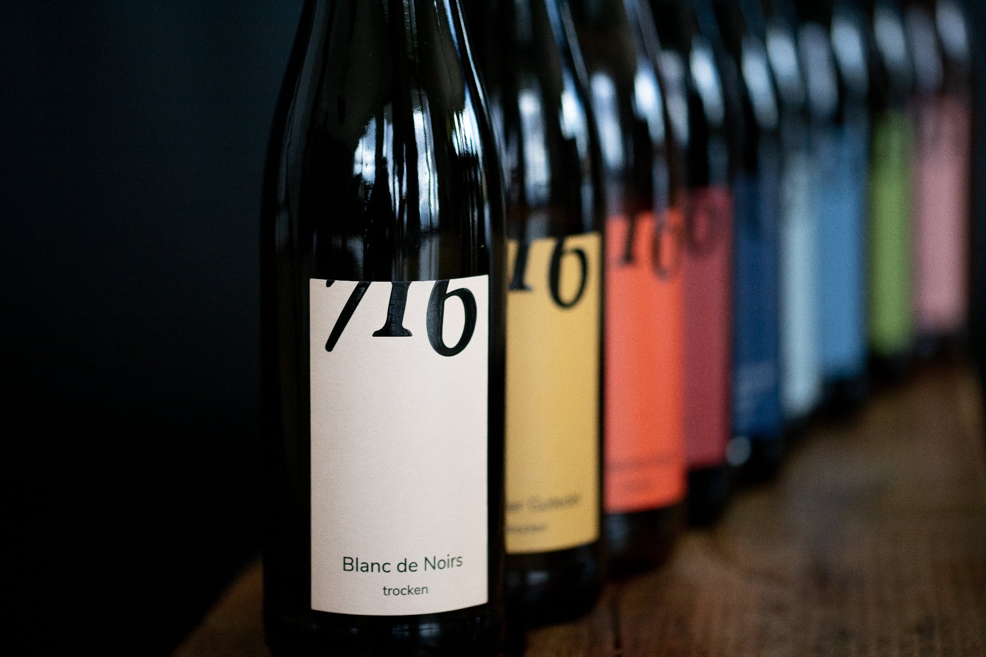 Mehrere Flaschen der 716 Weine in Reihe hintereinandergestellt.